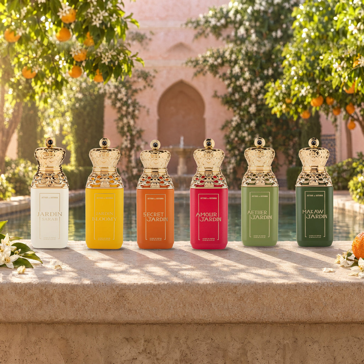 The six Jardin bottles, Sarab, Bloomy, Secret, Amour, Aether and Makaw, standing in a row on the limestone rim of a pool in a walled garden, orange trees and jasmine behind them in morning sun