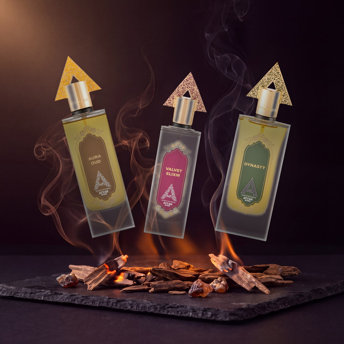 Aura Oud, Velvet Elixir and Dynasty floating above smouldering agarwood chips on black slate, threads of smoke rising between them